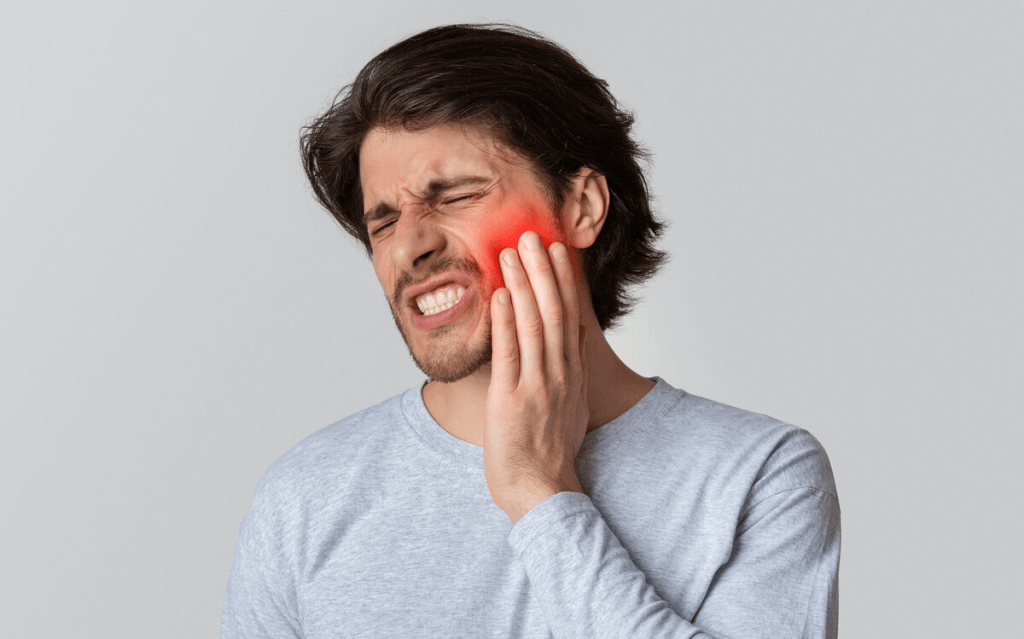 Man holding his cheek with a severe toothache