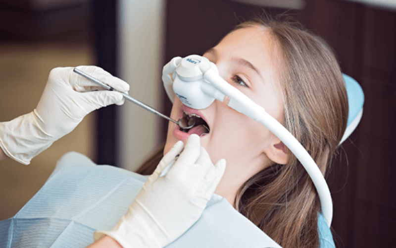 Young patient with a nasal sedation mask during treatment