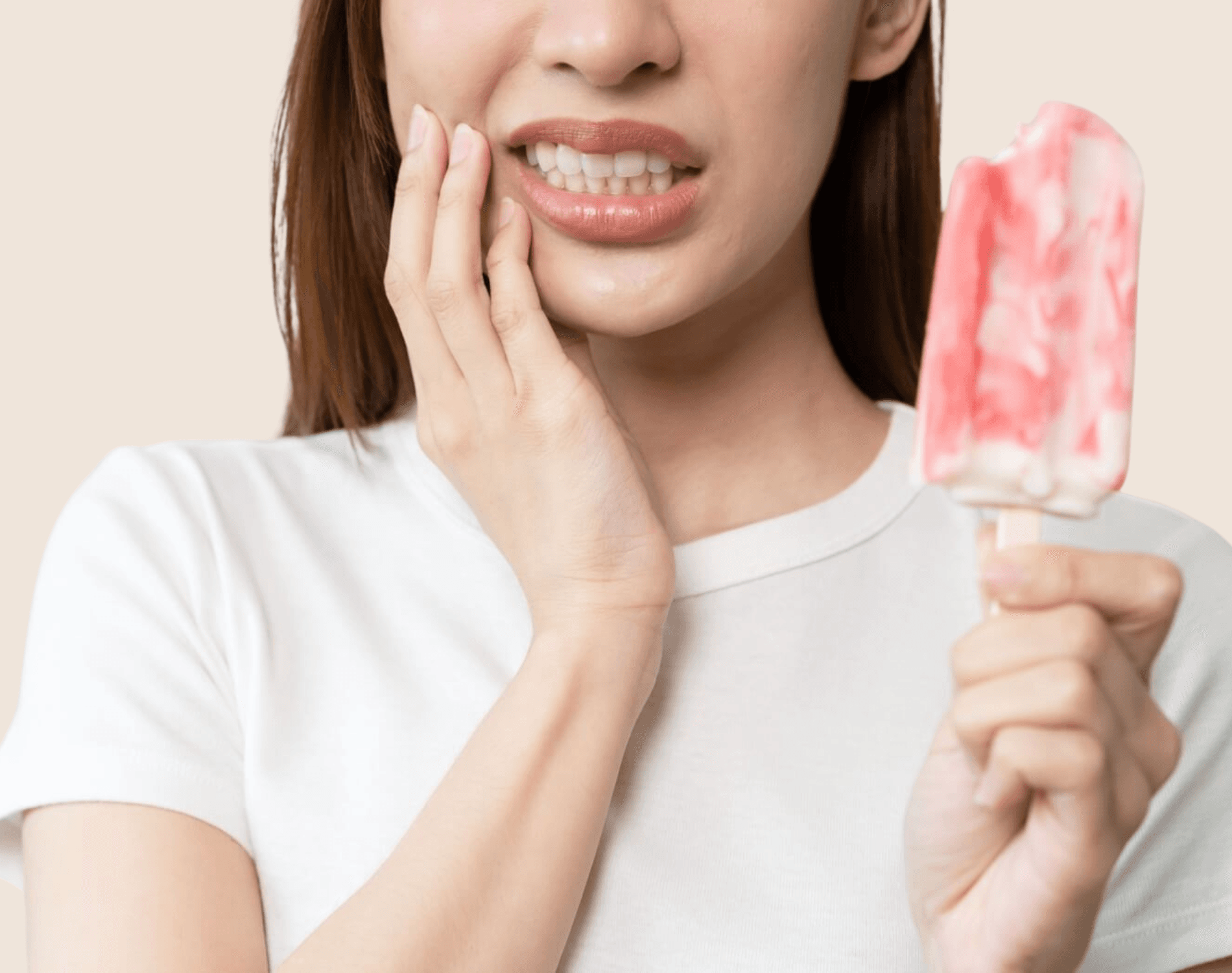 Woman wincing while holding a popsicle